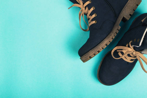 Winter woman boots on a blue background. Winter concept. top view Winter woman boots on a blue background. Winter concept womens blue suede shoes stock pictures, royalty-free photos & images