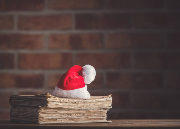 istock Christmas hat and old books 895856290