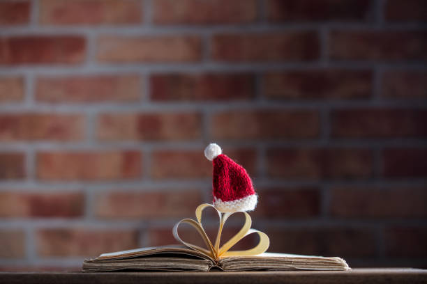 istock Santa Claus Christmas hat and old books 895856322