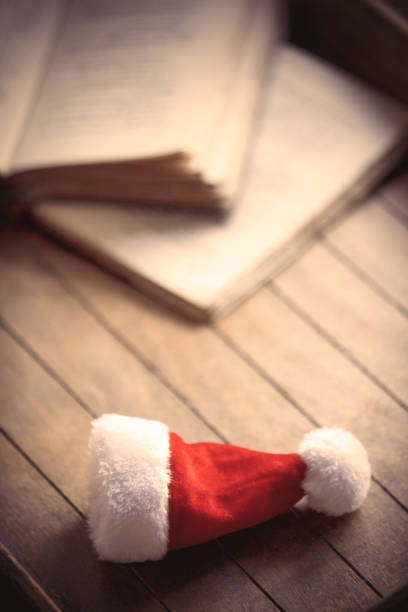 istock Santa Claus Christmas hat and old books 895856424