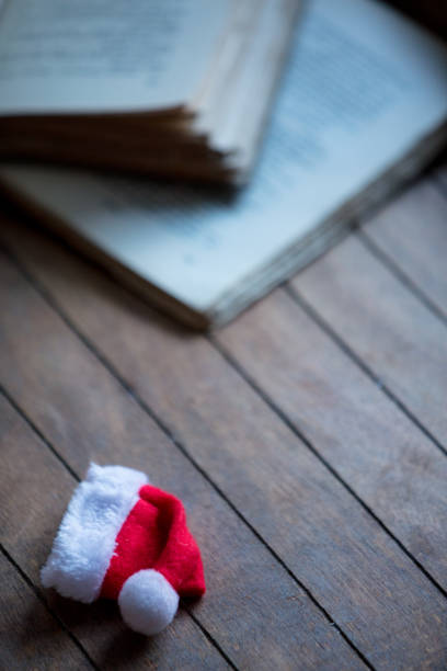 istock Santa Claus Christmas hat and old books 895856444
