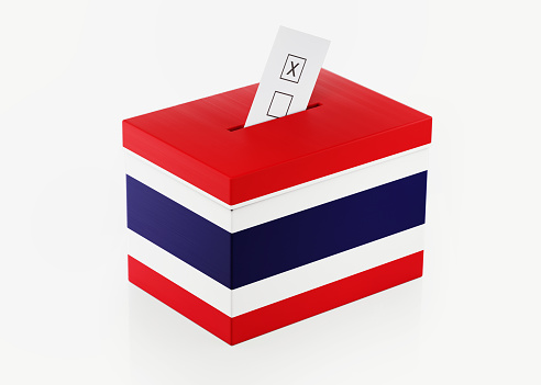 Ballot box textured with Thai flag. Isolated on white background. A vote envelope is entering into the ballot box. Horizontal composition with copy space. Great use for referendum and presidential elections related concepts. Clipping path is included.