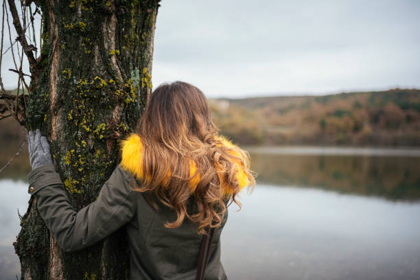 Beautiful woman in the forest hugging a tree. Nature concept.