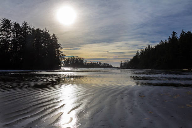 istock Sun sinks to horizon over rippled sand at Schooner Cove 895889024
