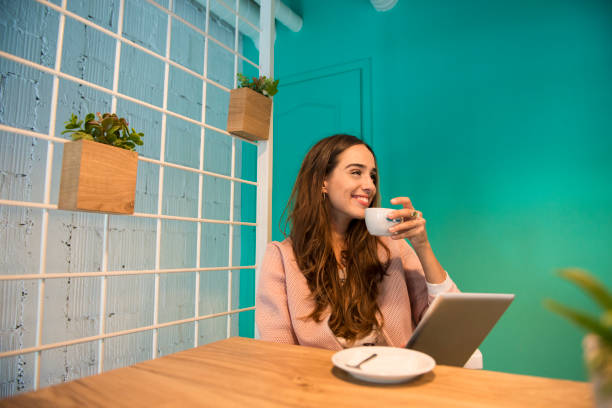 istock Smiling woman using digital tablet at the bar 895895214