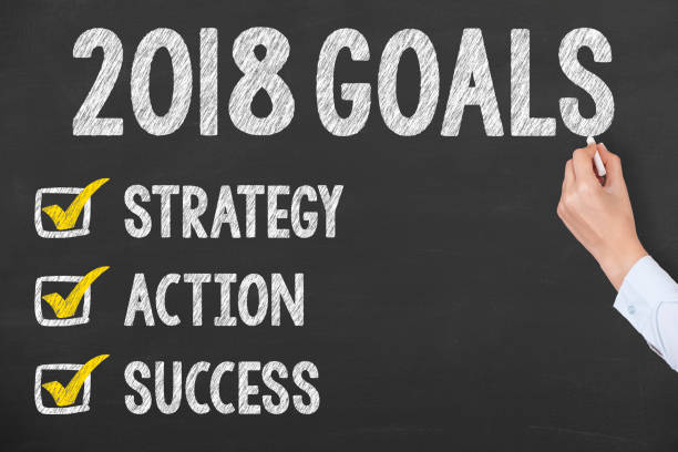 istock Human Hand Writing New Year 2018 Goals on Chalkboard 895911558