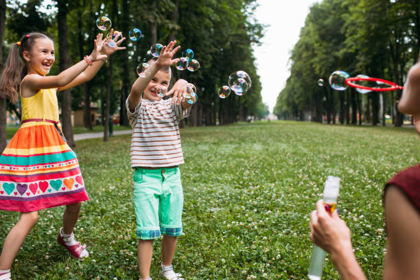istock Happy children blows bubbles park concept. 895936572
