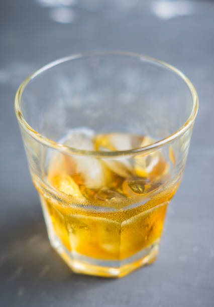 istock Glass with whiskey on the rustic wooden background 895957294