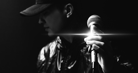 portrait of asian handsome singer posing on microphone, black and white