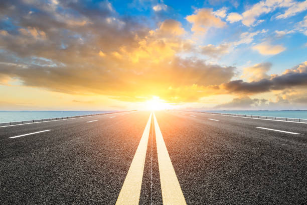 empty asphalt road and blue sea nature landscape at sunset