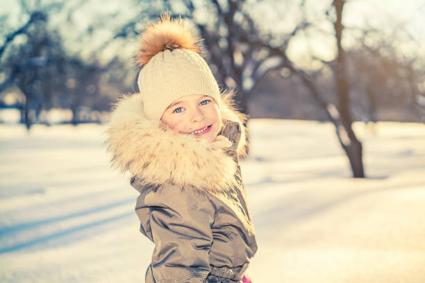 Portrait of little girl in sunny winter park