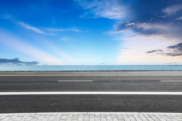 istock empty asphalt road and blue sea nature landscape at sunset 896016434