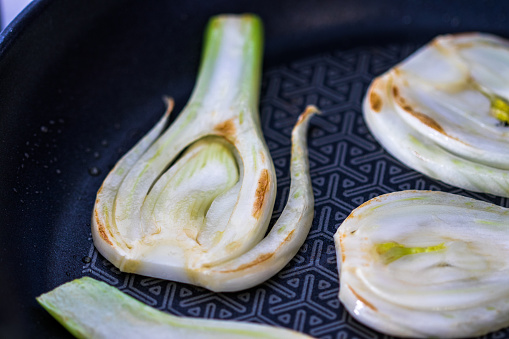 Slices of fresh fennel in a frying pan