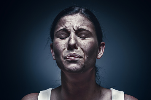 Cerca de retrato de una mujer llora con la piel amoratada y ojos negros photo