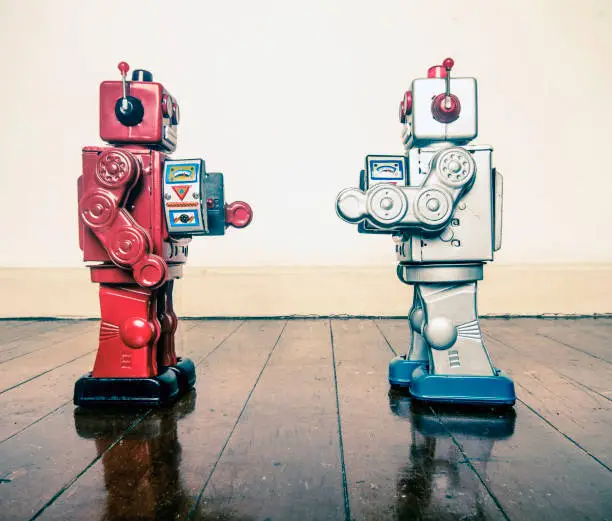 two retro robots face off with ray guns on a wooden floor with reflection