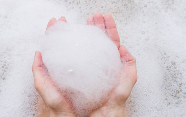 istock Bubble bath foam in woman's hands. Part of body, selective focus. 896032826