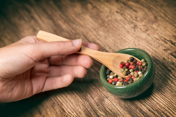 istock Hand Using Wooden Spoon To Take Peppers 896039954