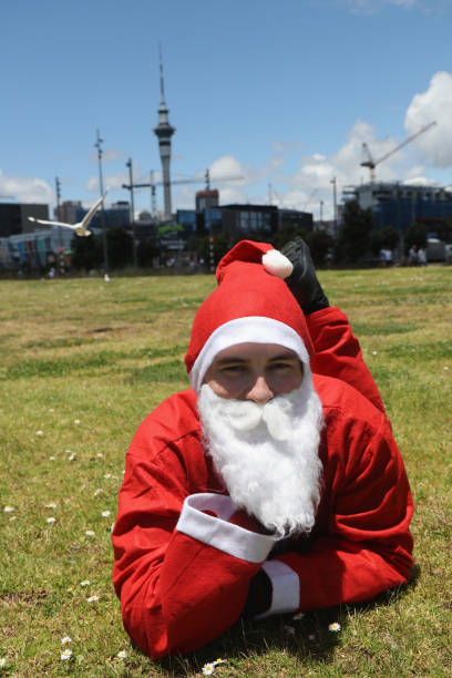 Papai Noel poses em frente a um cenário de cidade - foto de acervo