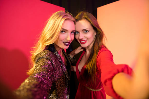 cheerful glamorous girls taking selfie in studio