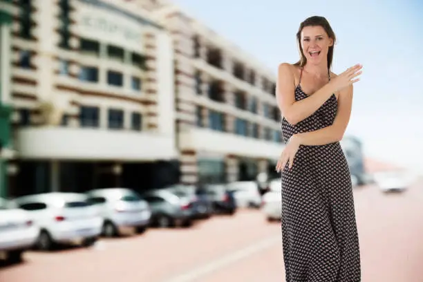 Photo of Happy young woman walks down a steet carefree and single
