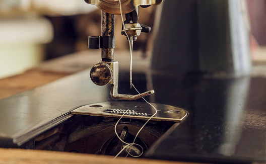 Close-up image of the needle of a vintage sewing machine.