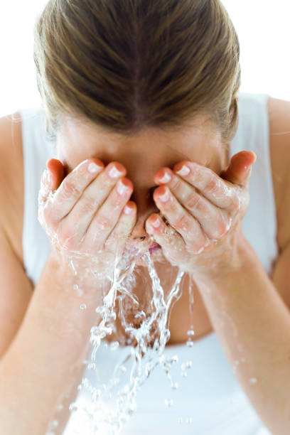 hermosa joven lava su rostro salpicaduras de agua en un baño de casa. - human face water washing women fotografías e imágenes de stock