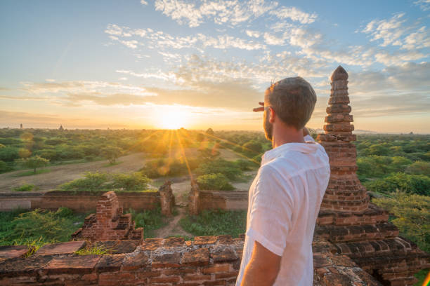 istock Young man contemplating the Bagan archeological zone at sunrise, Burma 896068648