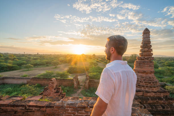 istock Young man contemplating the Bagan archeological zone at sunrise, Burma 896068756