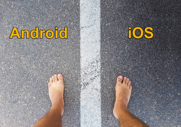 istock Android vs ios text on yellow arrows on asphalt ground, barefoot on floor, personal perspective footsie concept 896073272