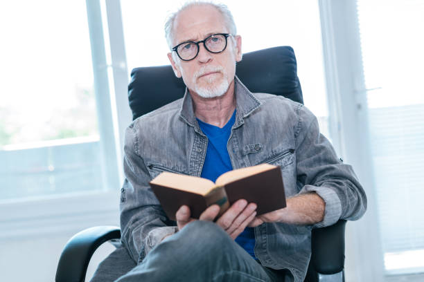 istock Portrait of mature man reading a book 896092738