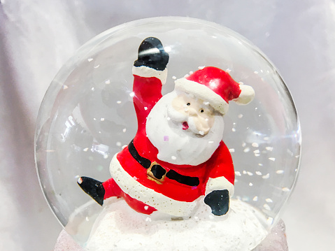 Christmas snow globe with deer wears santa's cloth  on table, with copy space