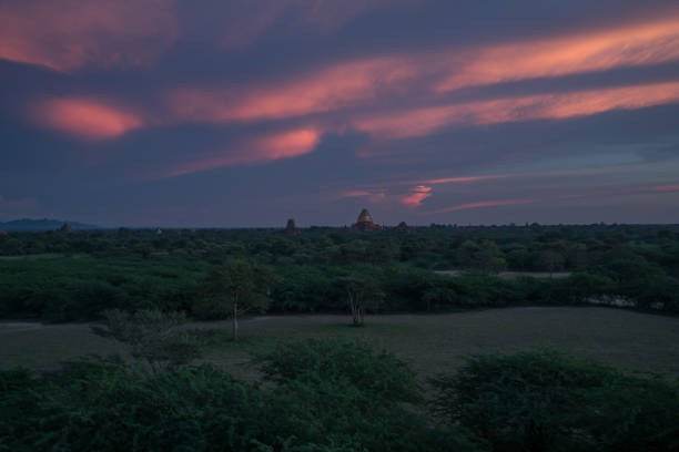 View of Bagan archeological zone at sunset in the monsoon season from a temple's roof. Stunning landscape with stupas, monasteries and temples. Bagan counts more than 2200 temples and stupas in the present day.