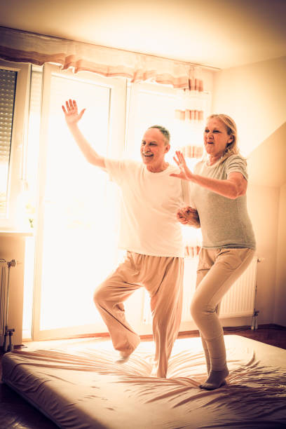 istock Senior couple  jumping together on bed. 896102064