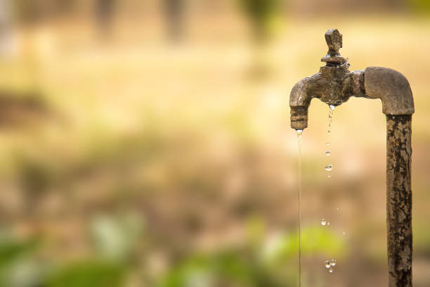 spadająca woda ze starego zardzewiałego kranu. selektywne skupienie, płytka głębia ostrości. - faucet heat water water pipe zdjęcia i obrazy z banku zdjęć