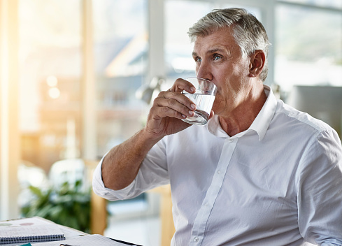 Shot of a mature businessman suffering with a headache at work