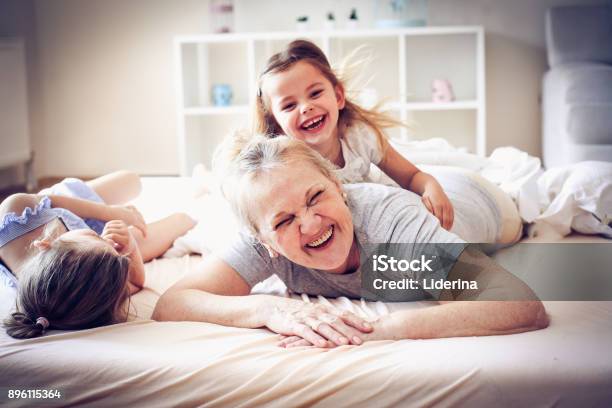 Playing In Bed Stock Photo - Download Image Now - Nanny, Grandparent, 6-7 Years