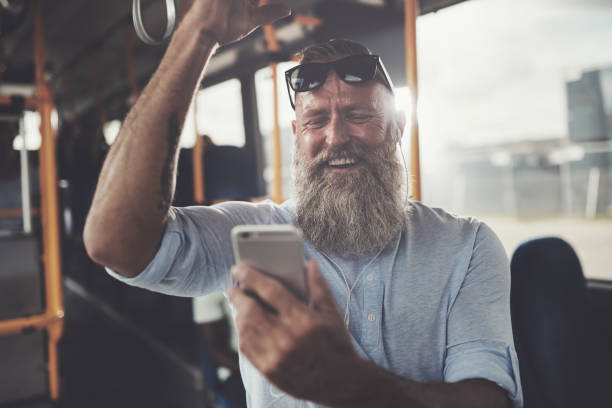 istock Mature man laughing while riding a bus listening to music 896141598