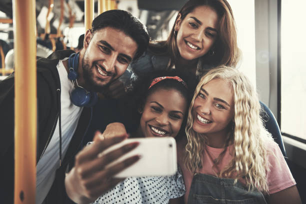 istock Friends smiling and taking selfies together on a bus 896141956