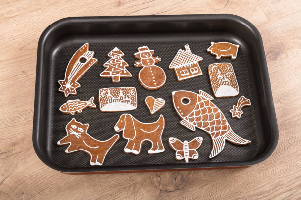 Baking sheet with cute hand-decorated biscuits on a wooden table