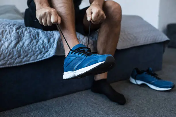 Photo of man tying sneaker laces