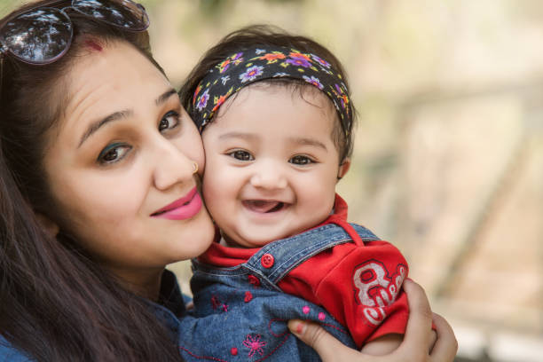 istock mother and daughter hugging and smiling at camera in the park. selective focus, shallow depth of field. 896148334