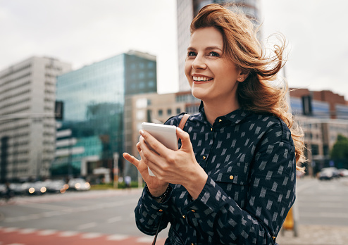 Shot of an attractive young woman using a mobile in the city