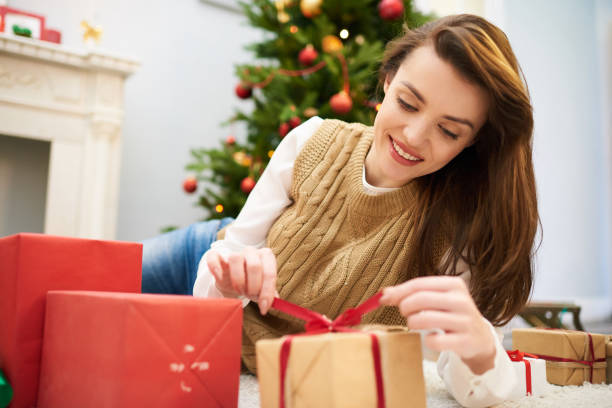 istock Curious Woman Unwrapping Christmas Gift Box 896157466
