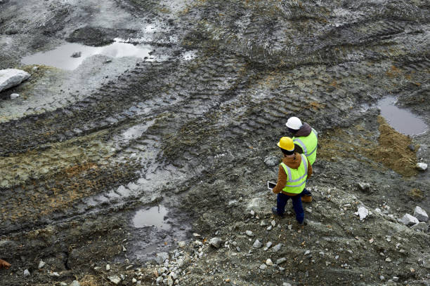 pracownicy spacerujący w błocie na miejscu - oil industry digital tablet manual worker mining zdjęcia i obrazy z banku zdjęć