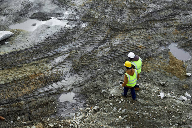 рабочие, гуляя в грязи на месте - oil industry digital tablet manual worker mining стоковые фото и изображения