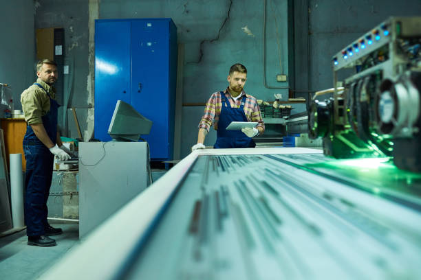 istock Workers Operating Laser Engraving Unit at Factory 896164210