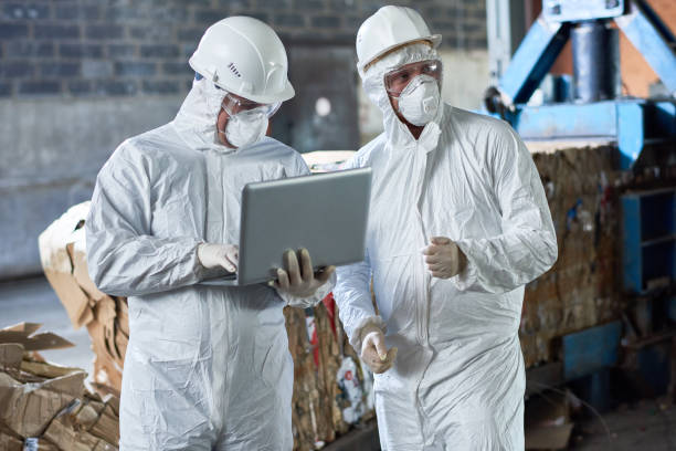arbeiter in hazmat anzügen im modernen recycling-werk - strahlenschutzkleidung stock-fotos und bilder