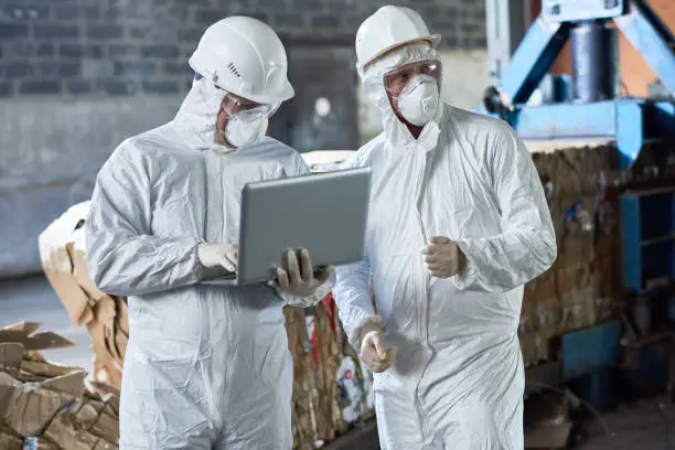 Photo of Workers in Hazmat Suits at Modern Recycling Factory