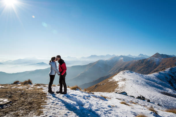 couple kissing on the mountains stock photo