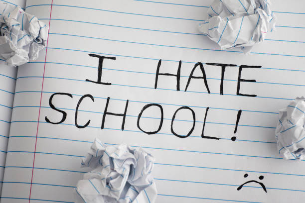 istock I Hate School. Phrase I Hate School on notebook sheet with some crumpled paper balls on it 896175348